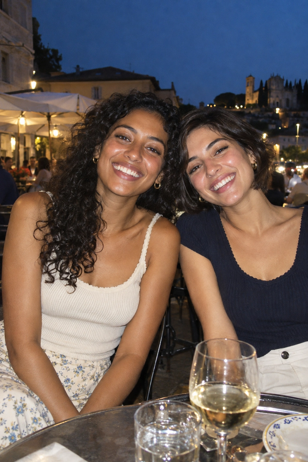 Illustrative digicam mood: two friends laughing together at an evening café