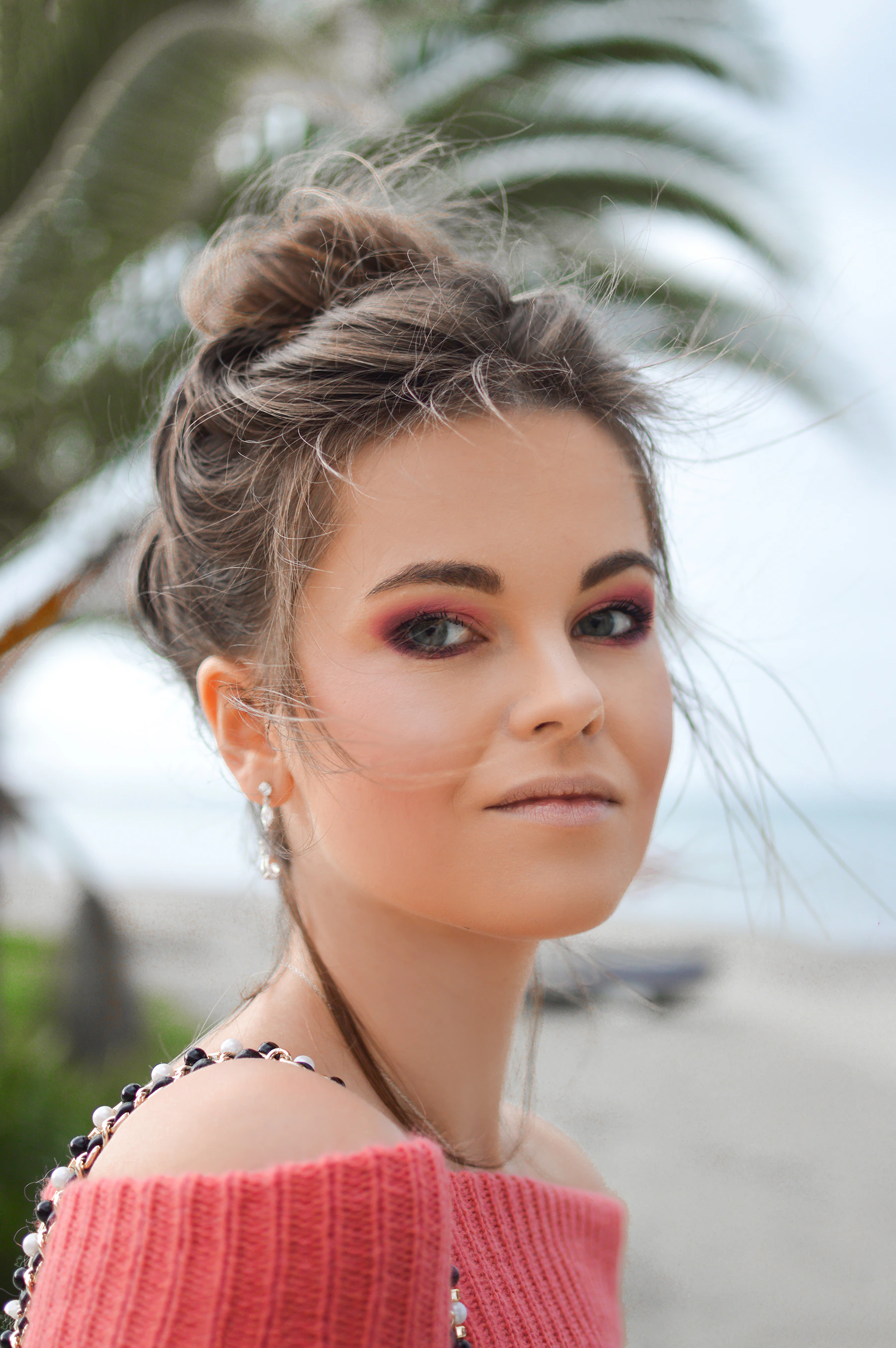 Woman in a coral sweater on the coast